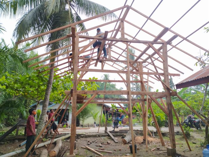 Caption foto: Masyarakat Kelurahan Teluk Sepang bergotong-royong mendirikan Rumah Pengaduan bagi Komunitas dalam melawan kerusakan lingkungan.