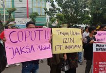 Caption foto: Massa aksi membentangkan poster copot Jaksa Nakal atas kasus pengerusakan jalan oleh PT. Injatama, Jumat (23/12/2022).